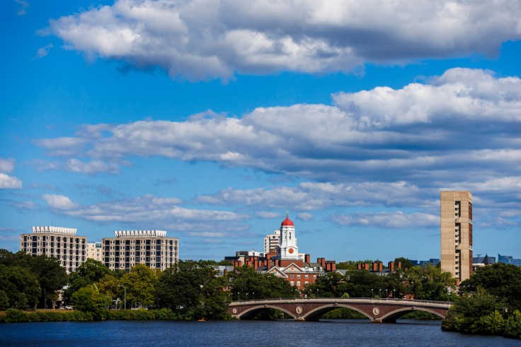 Harvard campus against blue skies, and the Charles River.