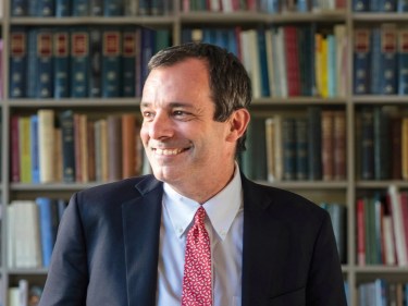 John F. Manning smiling in his office