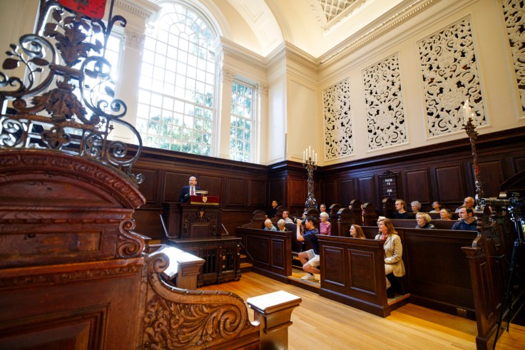 Alan Garber speaking at a podium in an ornate church.