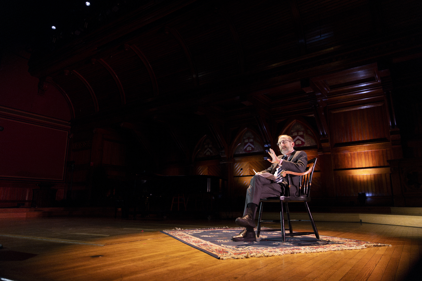 President Garber sitting in a spotlight on a stage.