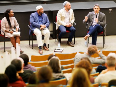 a panel of 4 people talking on stage