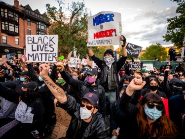 A crowd of people marching with signs