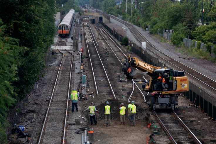 Workers remove sections of track on the Orange Line in Medford.