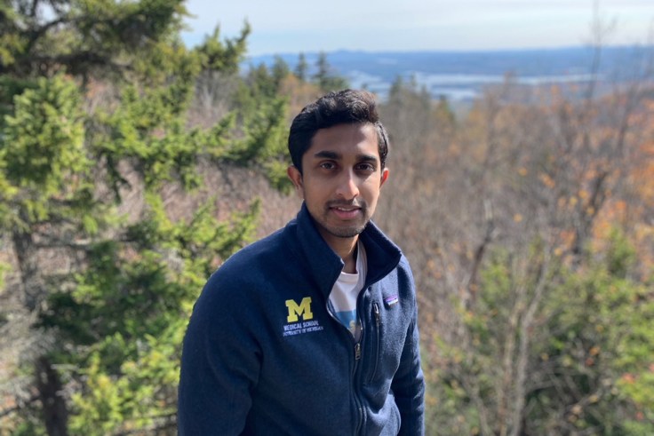 A student with views of trees and skies behind him