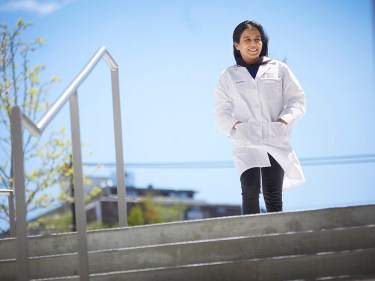 Sneha Dutta outside in a white lab coat