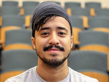 A man sits in a lecture hall