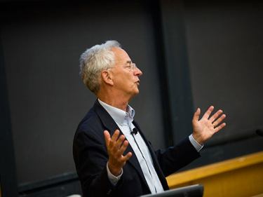 A professor talking in front of a podium