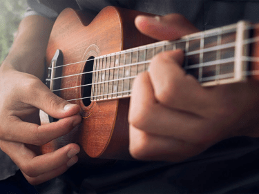 A close up of a person playing an acoustic guitar