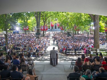 A speaker at a podium facing a huge audience