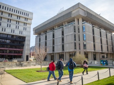 Students walk on campus between buildings