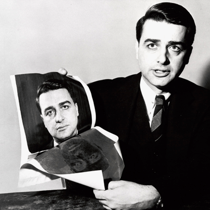 A man holding a photograph of himself