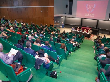 stadium-seating lecture hall with a projection of the inauguration graphic at the front of the class.