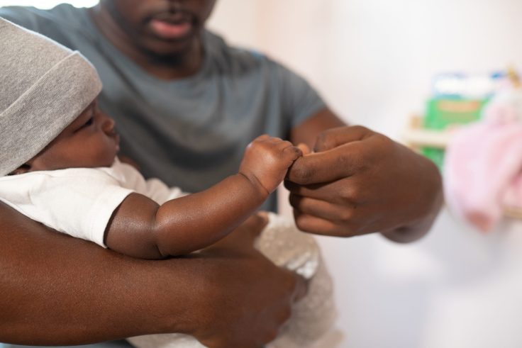 A dad holds a small baby