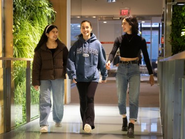 Students walking side by side down a hallway