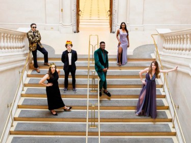 Students in dress clothes standing on the stairs