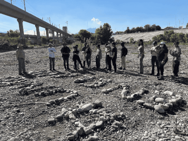 Harvard students standing in a dry river bed in Mexico