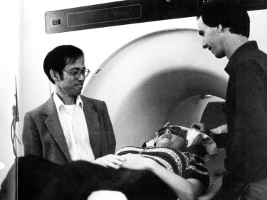 Black and white photo of someone going into an MRI machine