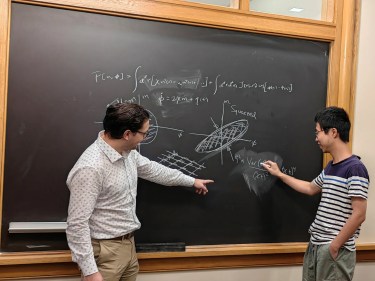 Two researchers working at a blackboard
