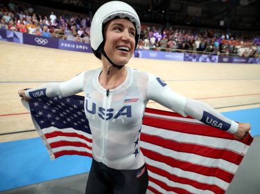 Kristen Faulkner with an American flag after winning gold in the Paris Olympics